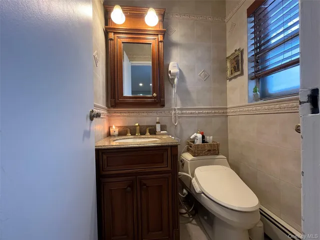a bathroom with a granite countertop toilet sink and mirror