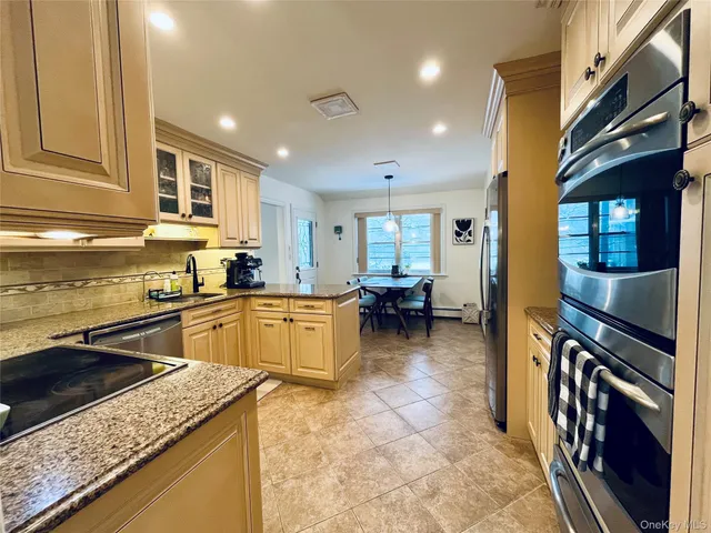a kitchen with stainless steel appliances granite countertop a sink stove and cabinets