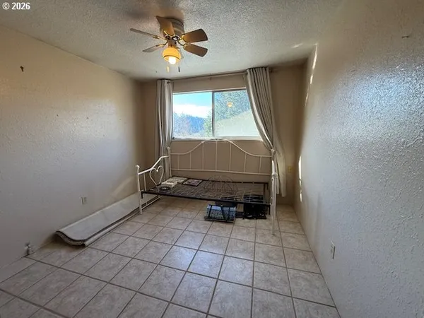 an empty room with windows and fan