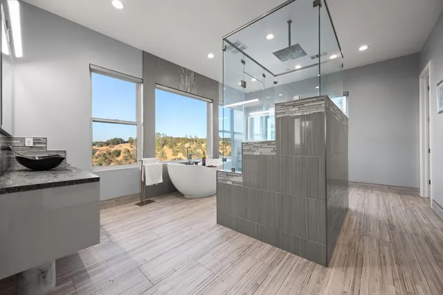 a bathroom with a granite countertop sink a toilet a mirror and shower