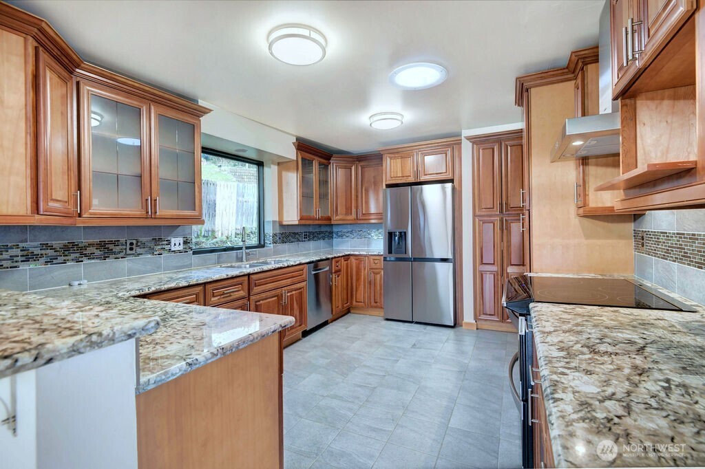 4322 29th Avenue West Seattle, WA 98199 - Photo 14 of 39 a kitchen with stainless steel appliances granite countertop a refrigerator a stove and a sink