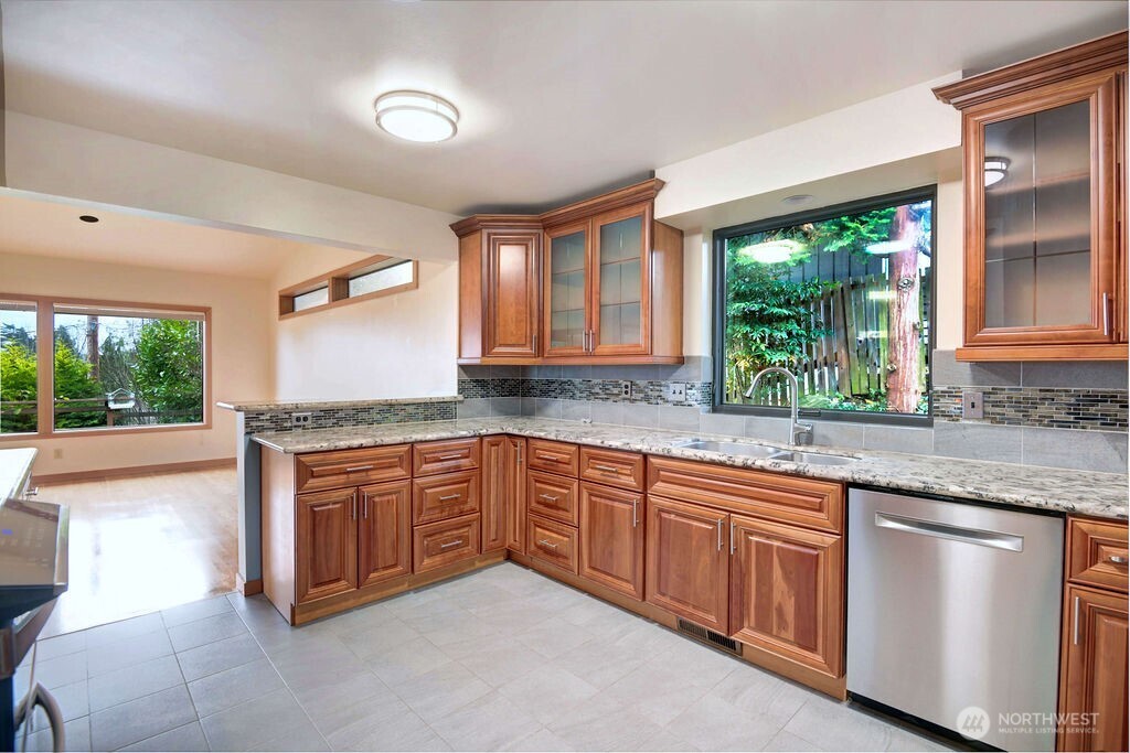 4322 29th Avenue West Seattle, WA 98199 - Photo 15 of 39 a kitchen with stainless steel appliances granite countertop wooden cabinets a sink and a large window