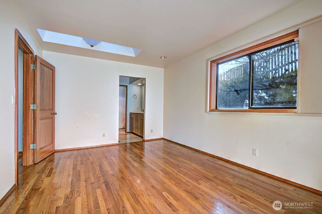 4322 29th Avenue West Seattle, WA 98199 - Photo 18 of 39 a view of an empty room with wooden floor and a window
