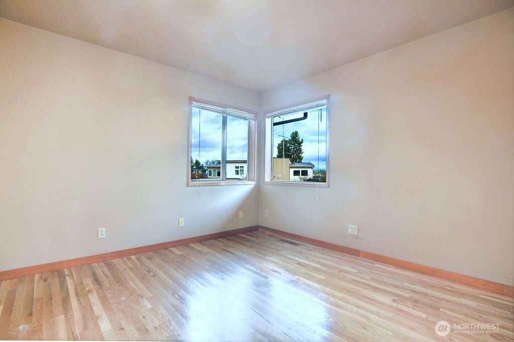4322 29th Avenue West Seattle, WA 98199 - Photo 24 of 39 an empty room with wooden floor and windows