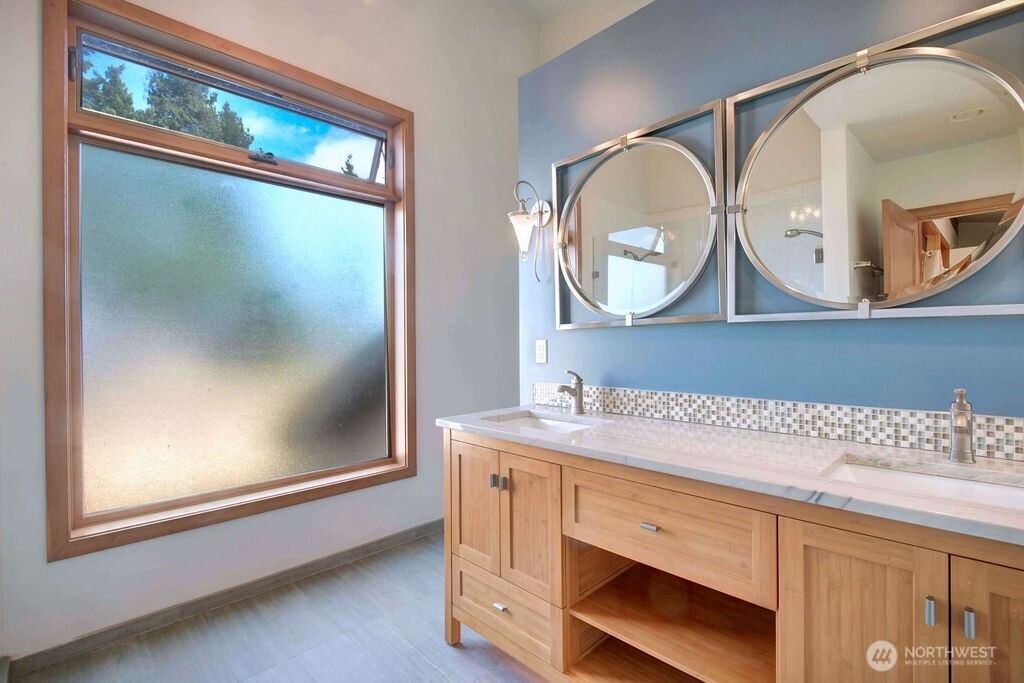 4322 29th Avenue West Seattle, WA 98199 - Photo 29 of 39 a bathroom with a sink a mirror a vanity and a window