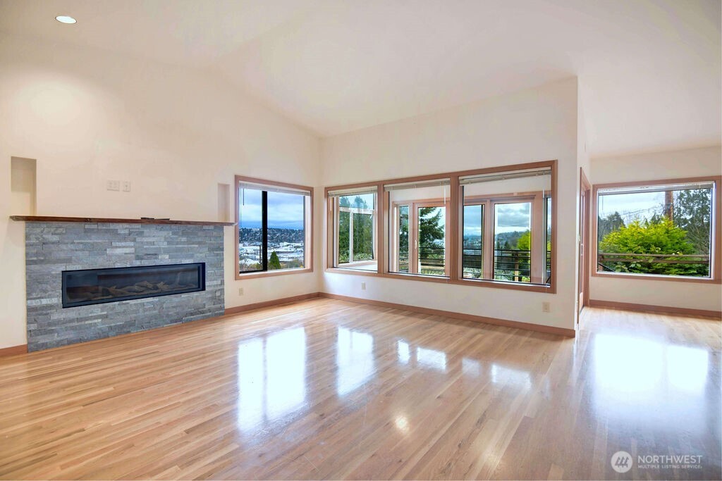 4322 29th Avenue West Seattle, WA 98199 - Photo 5 of 39 a view of an empty room with wooden floor fireplace and a window