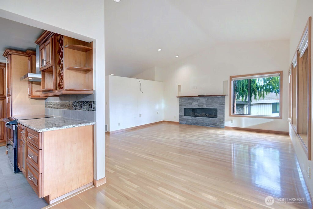 4322 29th Avenue West Seattle, WA 98199 - Photo 10 of 39 an empty room with a fireplace and wooden floor