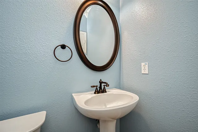 a bathroom with a sink a toilet and a mirror