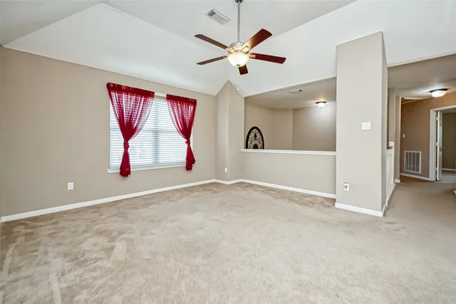 an empty room with windows and fan