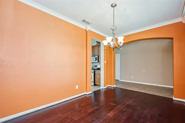 an empty room with wooden floor fan and window