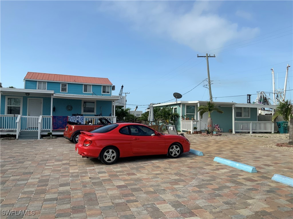1180 Main Street, Unit 6 Fort Myers Beach, FL 33931 - Photo 12 of 18 a front view of a house with parking space