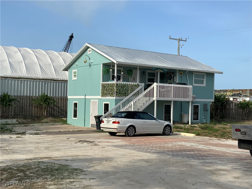 1180 Main Street, Unit 6 Fort Myers Beach, FL 33931 - Photo 14 of 18 a car parked in front of white house