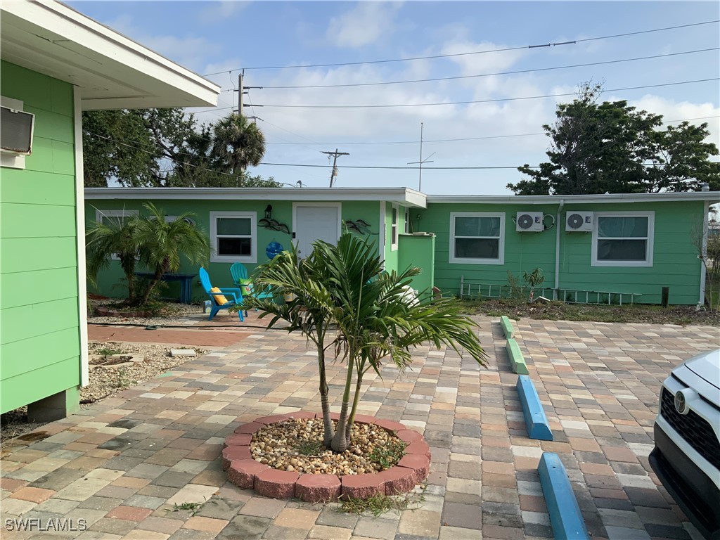 1180 Main Street, Unit 6 Fort Myers Beach, FL 33931 - Photo 5 of 18 a vase of flowers sitting in front of a house