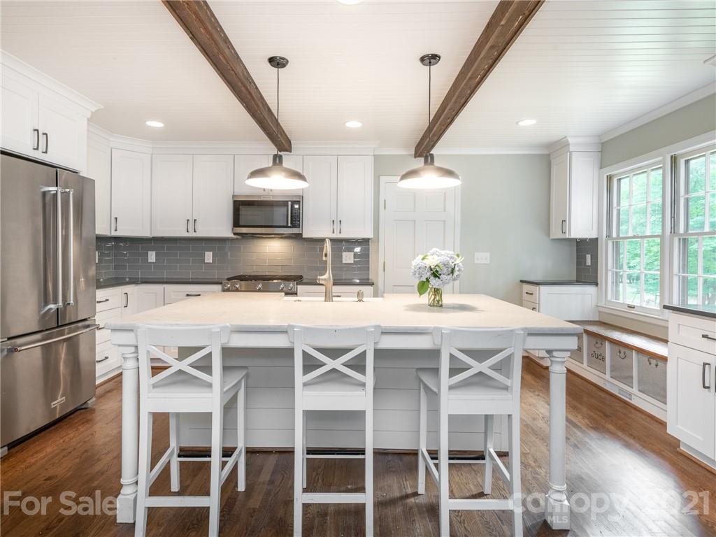 925 Reverdy Lane Matthews, NC 28105 - Photo 12 of 36 a kitchen with a table chairs refrigerator and microwave