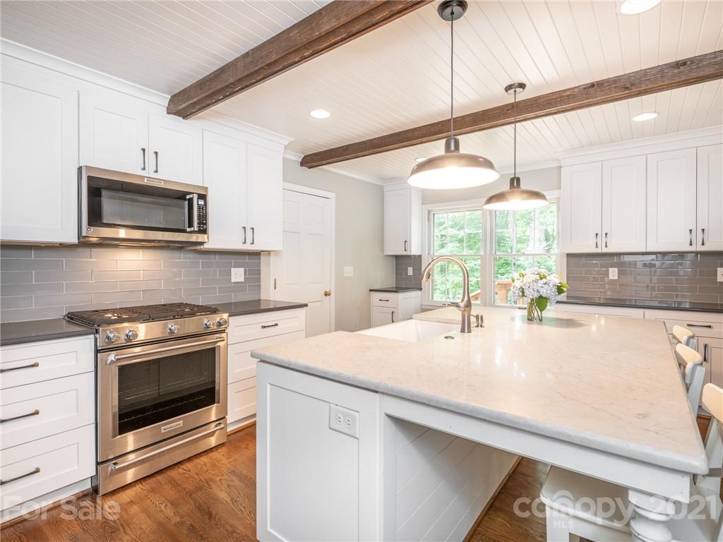 925 Reverdy Lane Matthews, NC 28105 - Photo 6 of 36 a kitchen with a stove a sink and a microwave