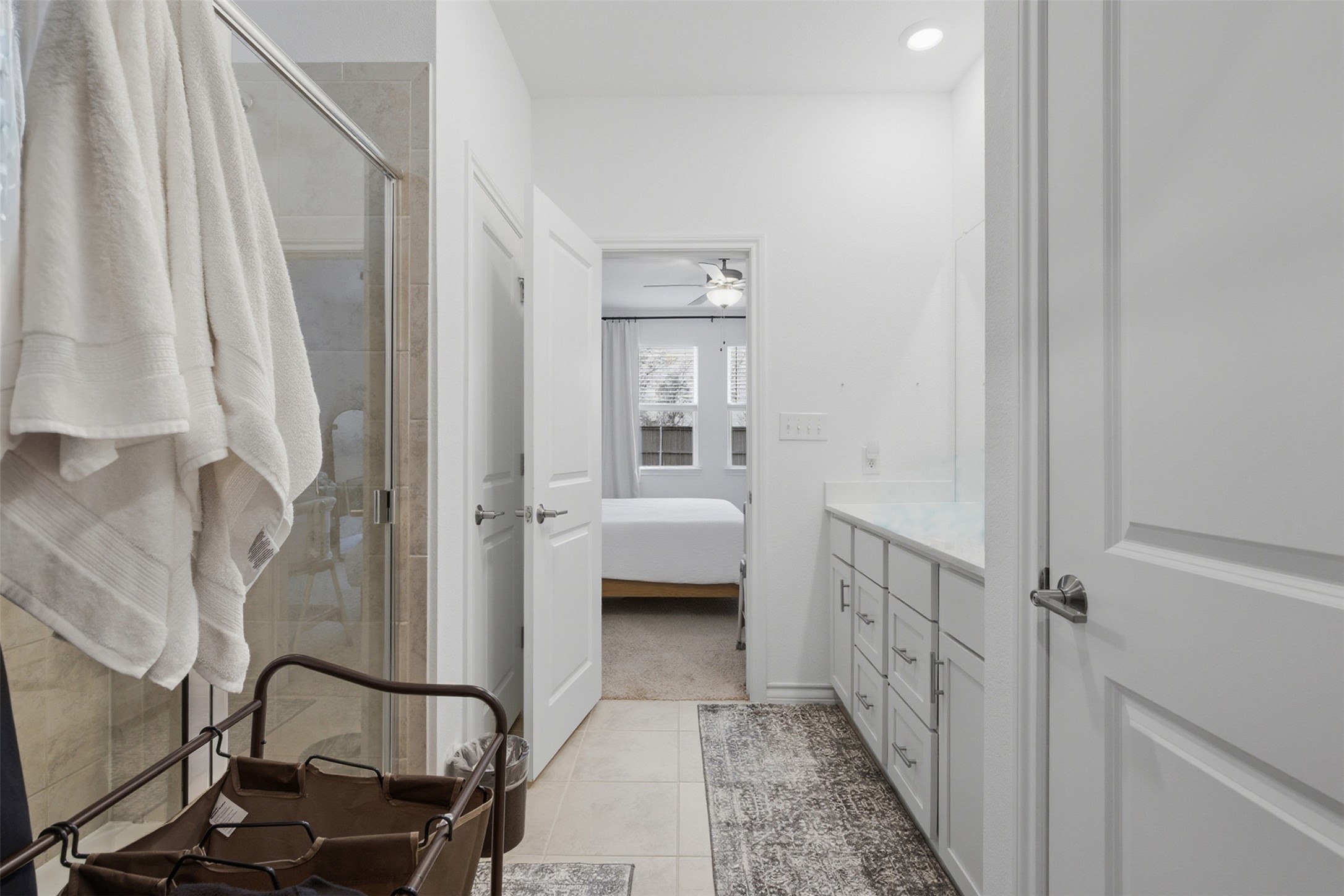203 Stinchcomb Road Hutto, TX 78634 - Photo 19 of 30 Full bathroom with connected bathroom, vanity, a stall shower, and light tile patterned flooring