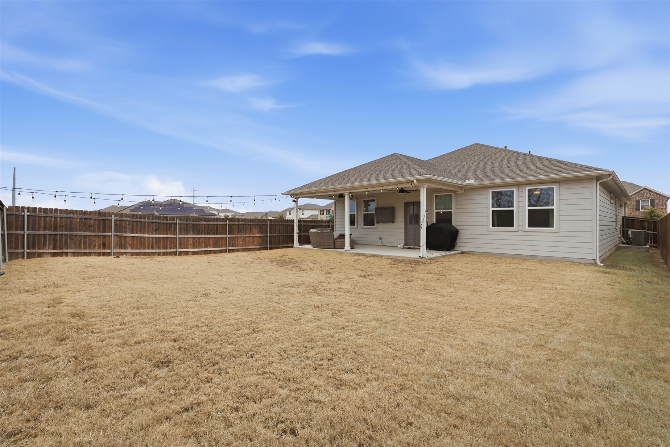 203 Stinchcomb Road Hutto, TX 78634 - Photo 26 of 30 Back of house with a patio area, a fenced backyard, a shingled roof, and ceiling fan
