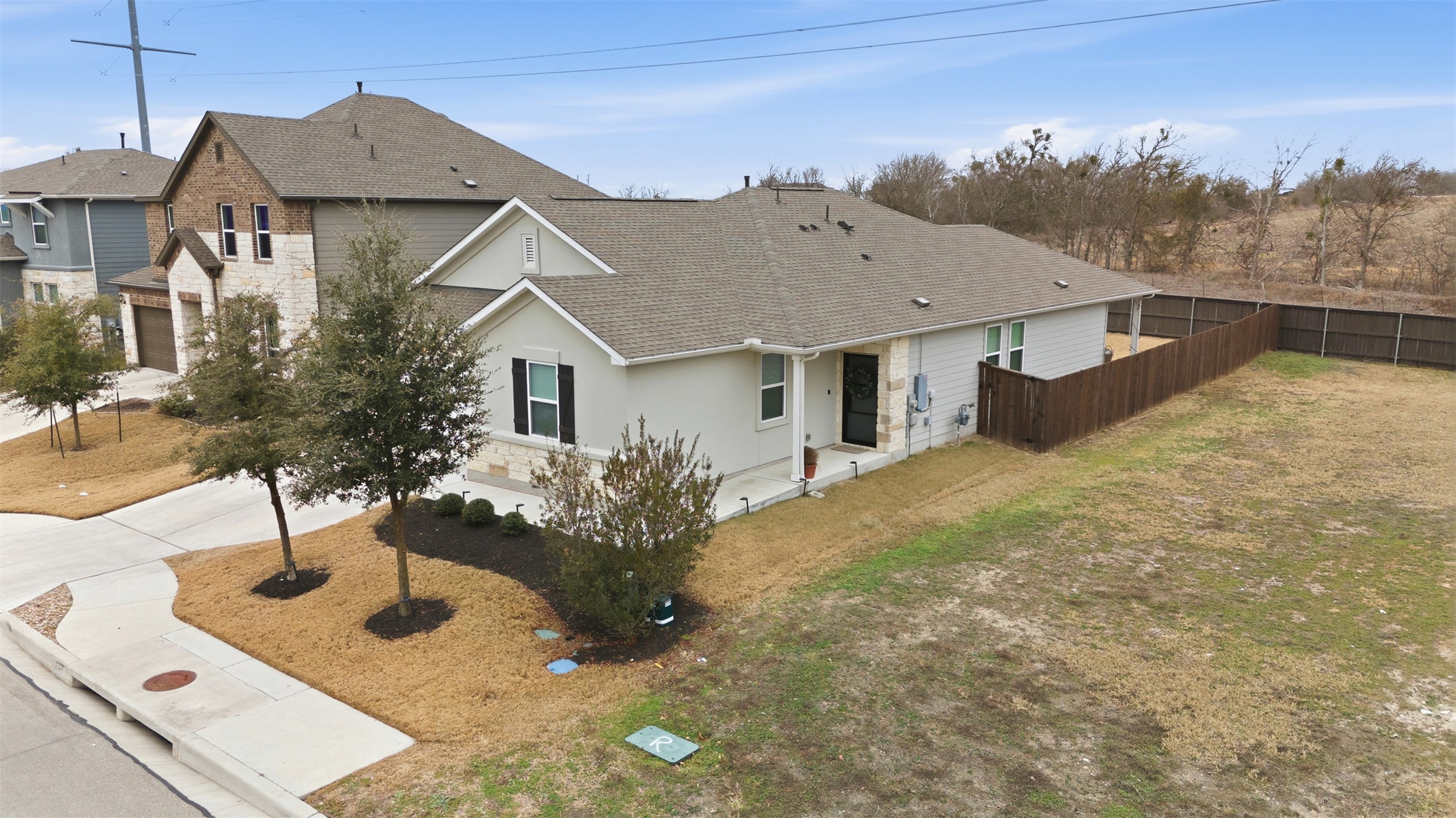 203 Stinchcomb Road Hutto, TX 78634 - Photo 3 of 30 View of front of home featuring a shingled roof, a patio, stone siding, and concrete driveway