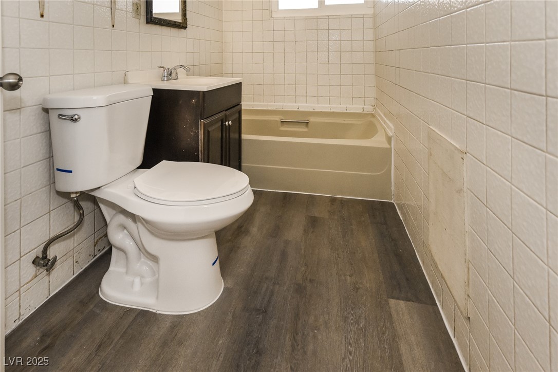 Undisclosed Address Las Vegas, NV 89107 - Photo 13 of 15 Full bathroom with a bath, tile walls, toilet, and