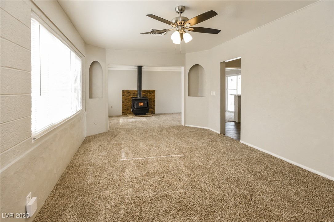 Undisclosed Address Las Vegas, NV 89107 - Photo 2 of 15 Unfurnished living room featuring a wood stove, ca
