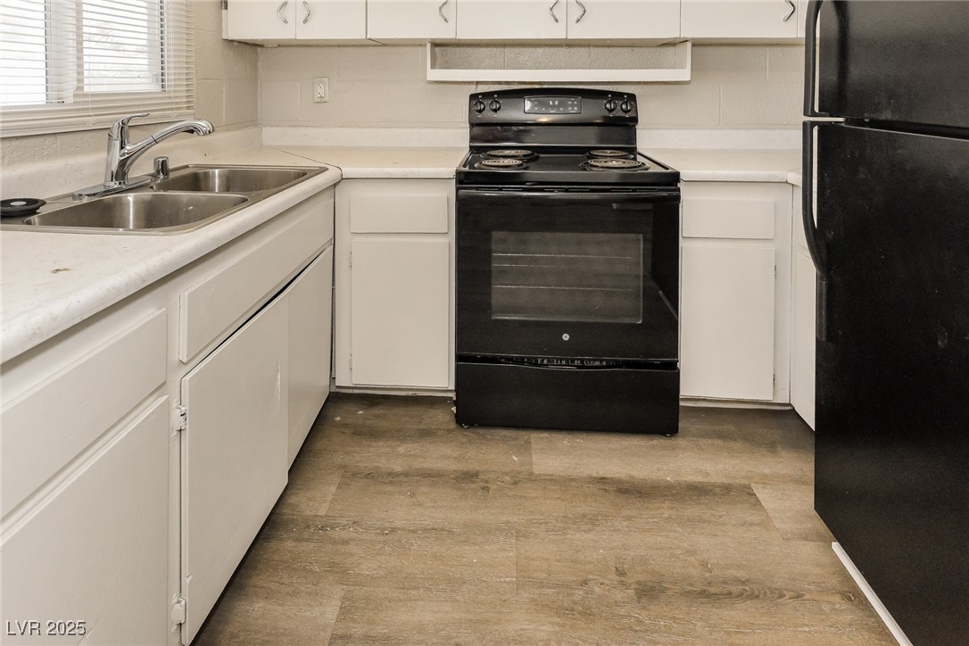 Undisclosed Address Las Vegas, NV 89107 - Photo 7 of 15 Kitchen with light countertops, a sink, white cabi