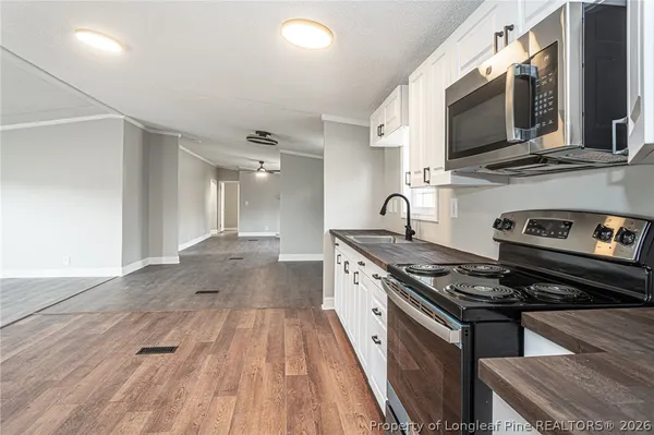 a kitchen with stainless steel appliances a stove a sink and a microwave