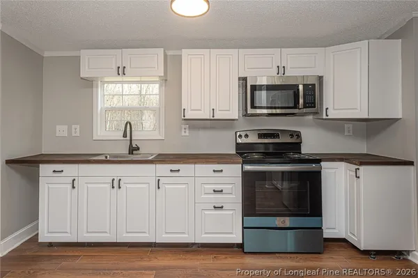 a kitchen with white cabinets stainless steel appliances and sink