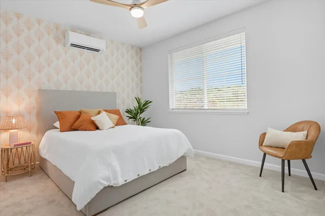 a bedroom with a bed chair and a window