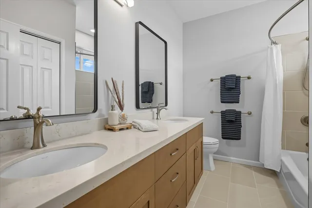 a bathroom with double vanity sink and two mirror