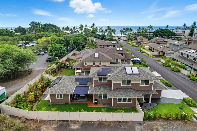 an aerial view of multiple houses with a yard