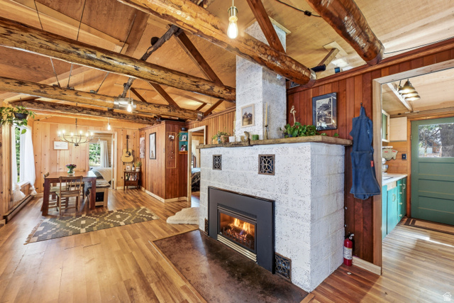 6631 Pine Springs Road Kamas, UT 84036 - Photo 48 of 48 Living area with light wood-style floors, a tile fireplace, plenty of natural light, vaulted ceiling with beams, and wooden walls