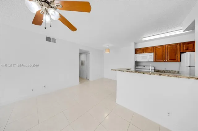 a view of kitchen with granite countertop cabinets and a window