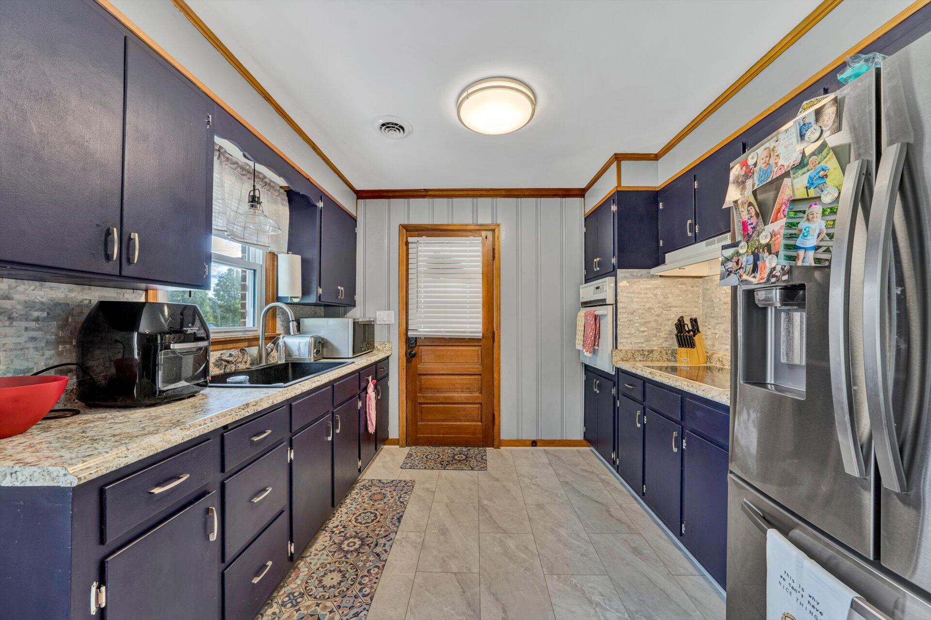6203 Roberta Road Roanoke, VA 24019 - Photo 8 of 28 a kitchen with stainless steel appliances granite countertop a refrigerator a stove and a sink with wooden floor