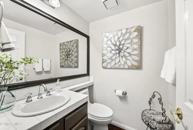 a bathroom with a sink a toilet and a mirror