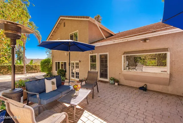 a patio with couches under an umbrella