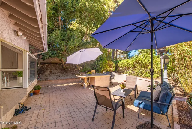a view of a patio with table and chairs under an umbrella