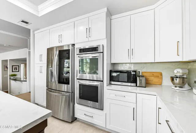 a kitchen with stainless steel appliances white cabinets and a refrigerator