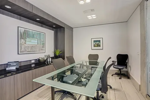 a view of a workspace with furniture and wooden floor