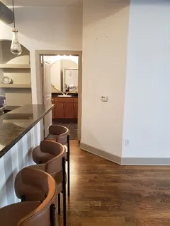 a kitchen with stainless steel appliances granite countertop a sink a stove and a wooden floor