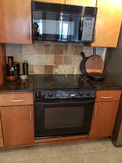 a kitchen with granite countertop a refrigerator stove and microwave
