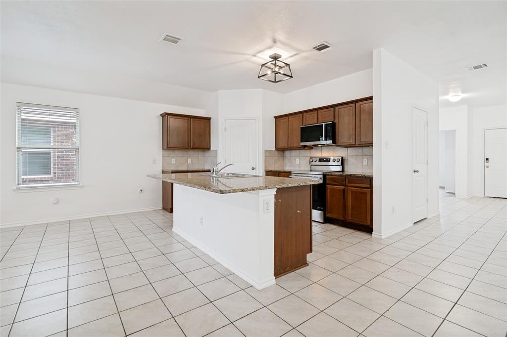 3415 Emerson Road Forney, TX 75126 - Photo 5 of 26 a kitchen with stainless steel appliances a sink and a stove top oven