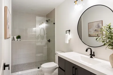 a bathroom with a sink a toilet and shower