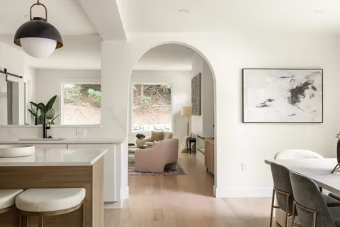 a living room with furniture a window and a potted plant