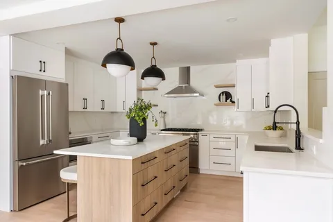 a kitchen with stainless steel appliances a stove refrigerator and cabinets