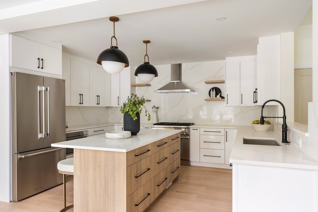 76 Harding Street Newton, MA 02465 - Photo 7 of 27 a kitchen with stainless steel appliances a stove refrigerator and cabinets