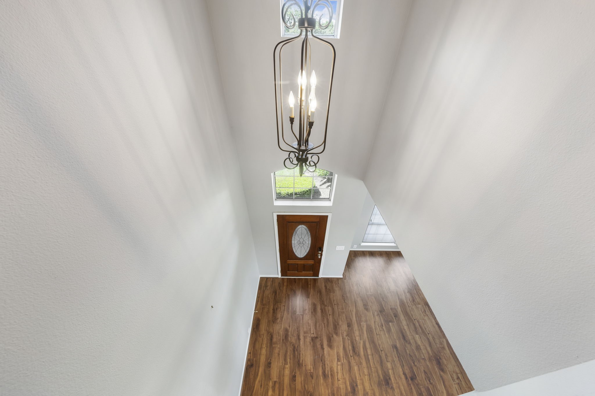 2907 Stemwood Drive Spring, TX 77388 - Photo 25 of 33 Dramatic two-story entry featuring soaring ceilings, rich wood-look flooring, oversized windows for abundant natural light, and an elegant chandelier creating a grand first impression.