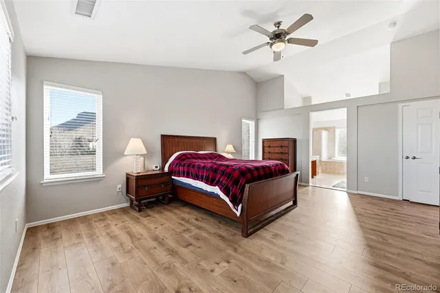 a spacious bathroom with a granite countertop sink a large mirror and a bathtub