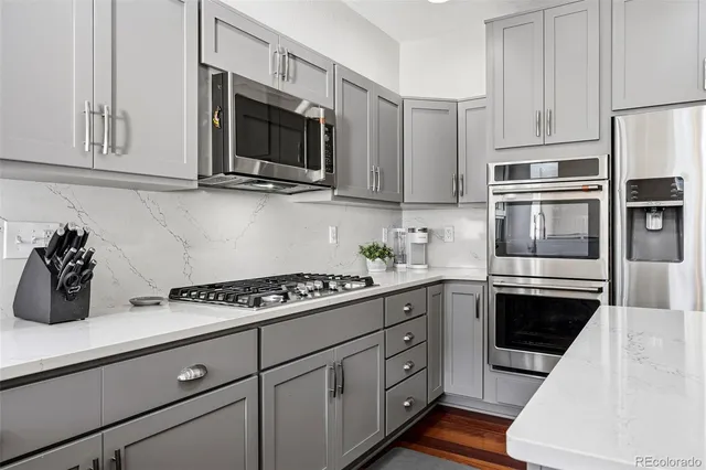a kitchen with stainless steel appliances granite countertop a sink stove and microwave