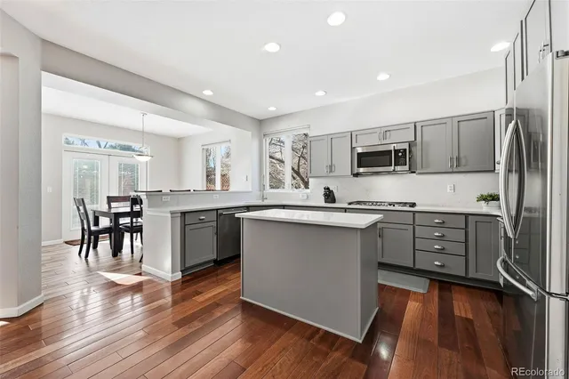 a kitchen with stainless steel appliances a sink cabinets and wooden floor