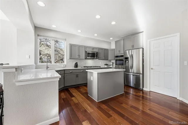a kitchen with a refrigerator sink and cabinets